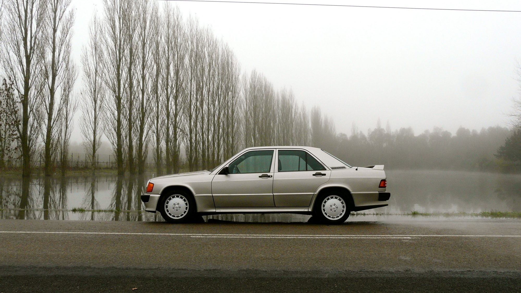 A trio of vintage Mercedes Benz W201 models showcased in an outdoor setting, emphasizing their classic design and appeal.