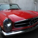 Classic Mercedes 230SL Pagoda in silver, parked outdoors.