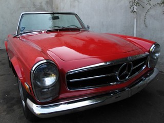 Classic Mercedes 230SL Pagoda in silver, parked outdoors.