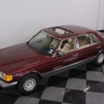 Front three-quarter view of a Cabernet Red 1985 Mercedes-Benz 500SEL, highlighting its classic W126 design.