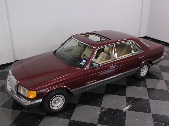 Front three-quarter view of a Cabernet Red 1985 Mercedes-Benz 500SEL, highlighting its classic W126 design.