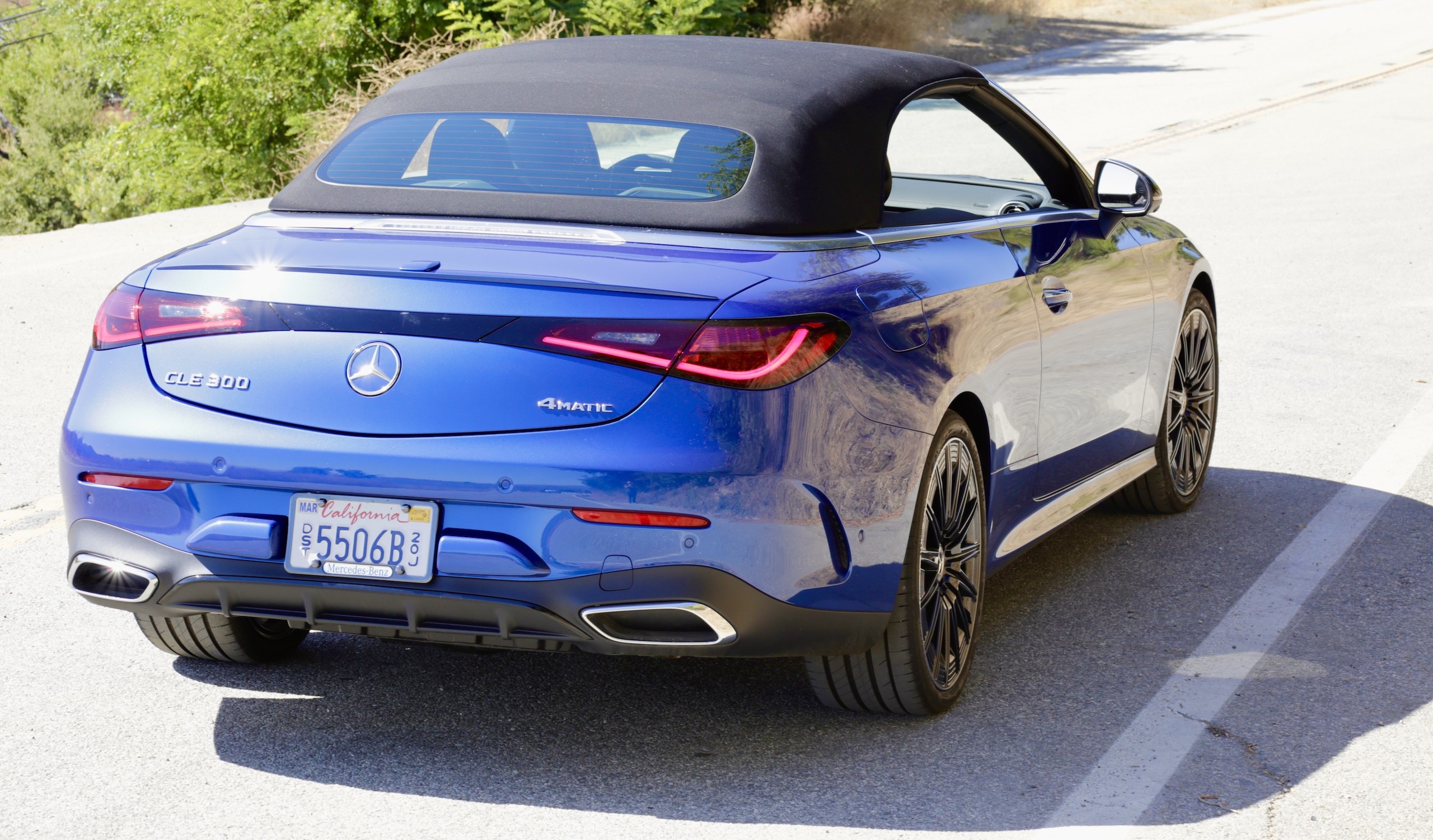 Front three quarter view of the 2024 Mercedes-Benz CLE300 Cabriolet with the top down, showcasing its open-air appeal.