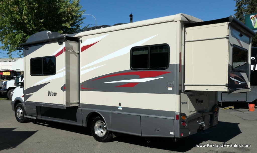 Interior view of the RV cab area featuring swivel captains seats and infotainment system.