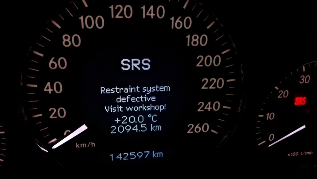 Mercedes dashboard displaying the SRS (Supplemental Restraint System) malfunction warning light, indicating a potential issue with safety systems.