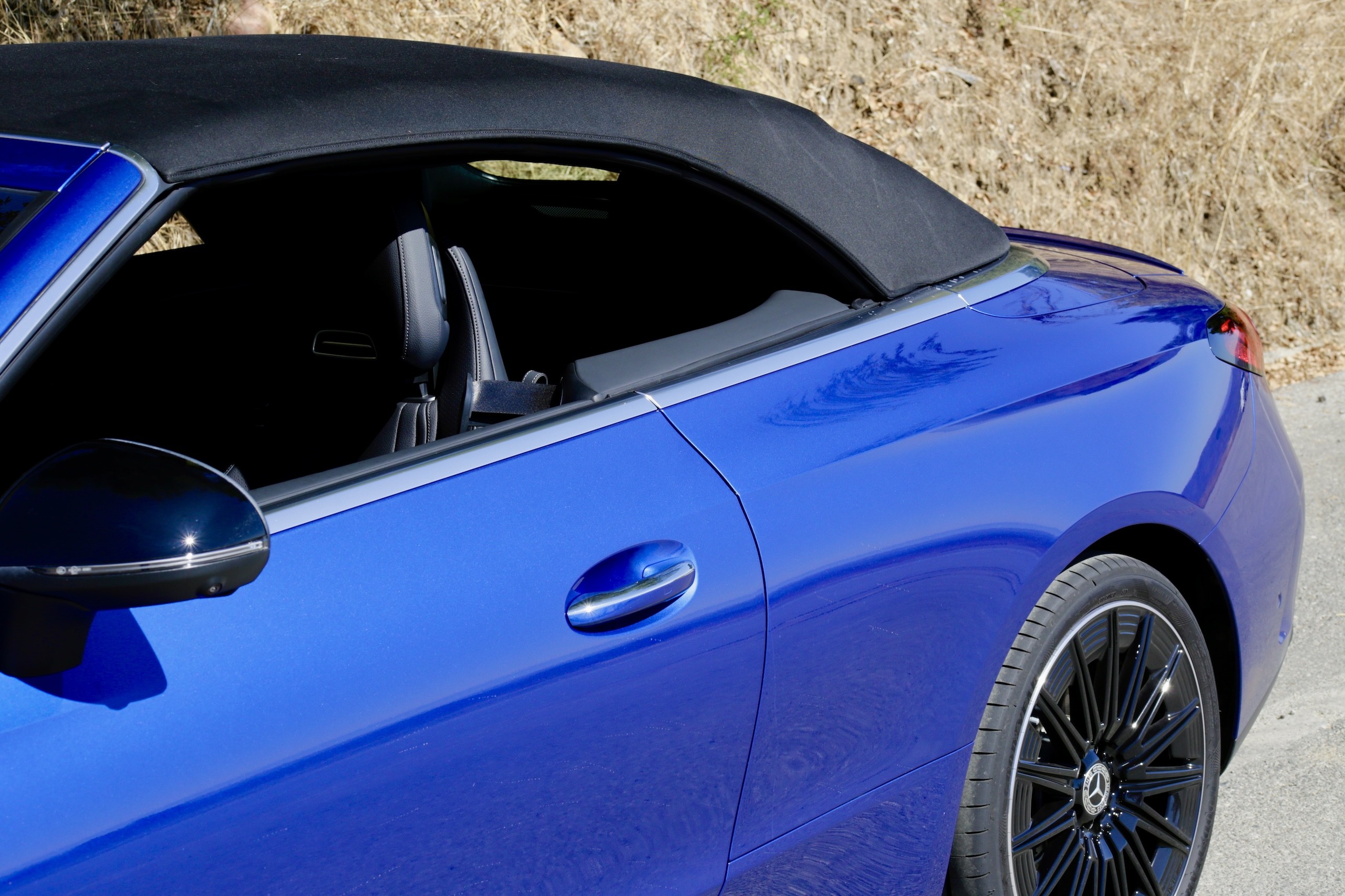 Rear three quarter view of the 2024 Mercedes-Benz CLE300 Cabriolet with the top down, emphasizing its elegant rear design.