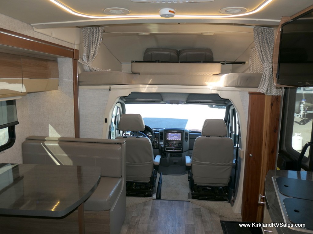 RV bathroom interior featuring shower, toilet, sink, and storage.