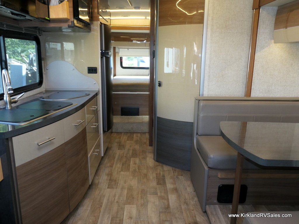 RV bedroom with queen-size bed in slide-out section and wardrobe closet.