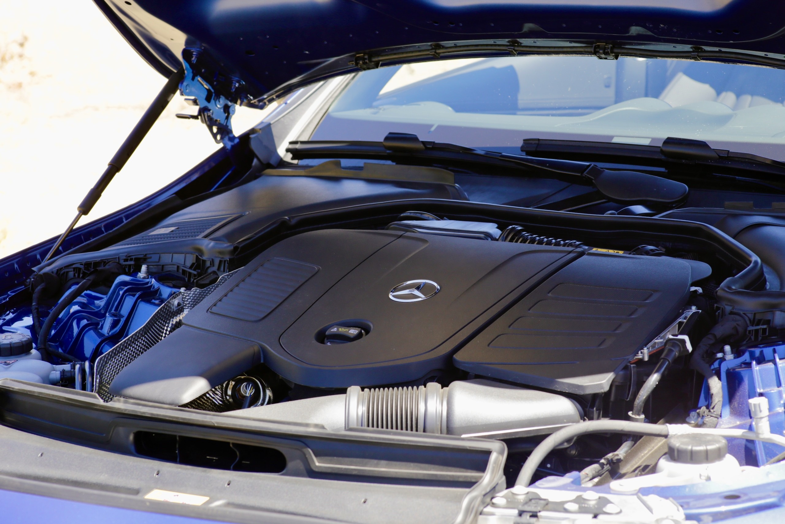 Side view of the 2024 Mercedes-Benz CLE300 Cabriolet in motion, showing its sporty proportions and open-top driving experience.